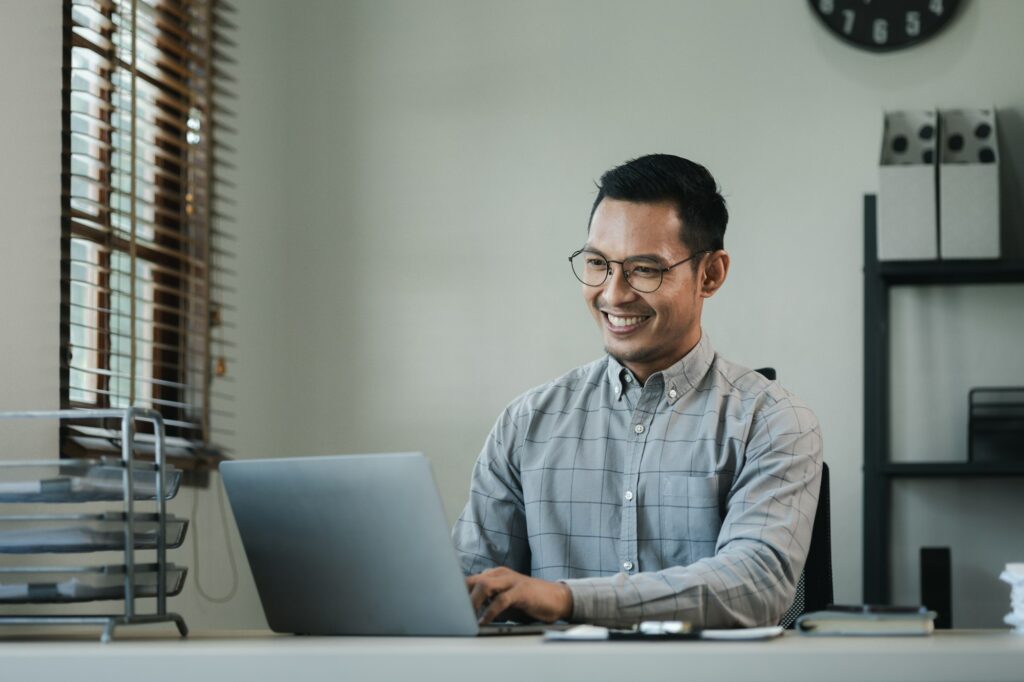 Businessman is sitting and working in the office, Employee is looking for information on laptop, An
